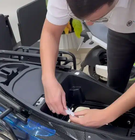 Técnico da RRDrones fazendo manutenção elétrica em uma scooter na oficina em Campinas